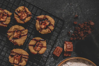 Close-up of a warm chocolate chip cookie with melting chips on a rustic wooden table