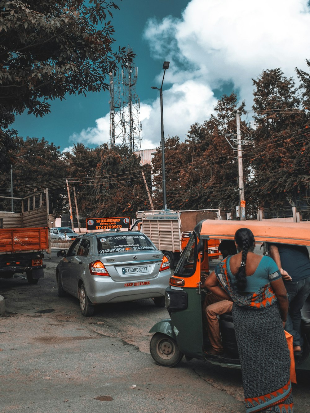 man in black t-shirt and black pants sitting on orange and black car during daytime