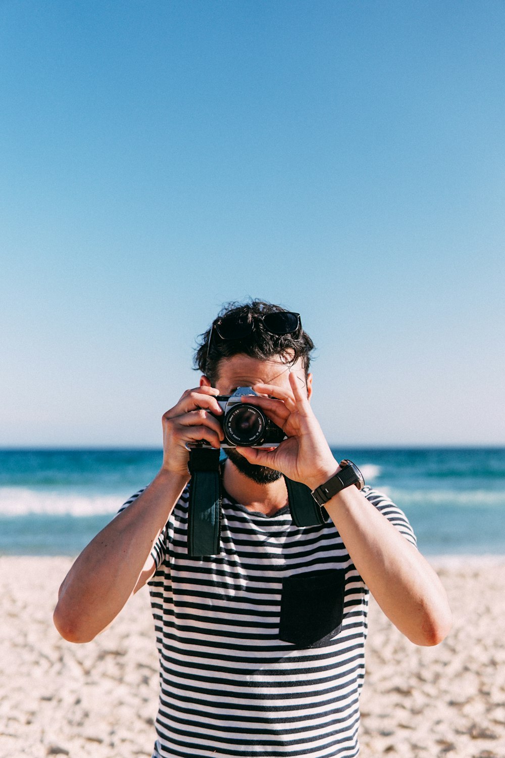 woman in black and white stripe shirt holding black dslr camera