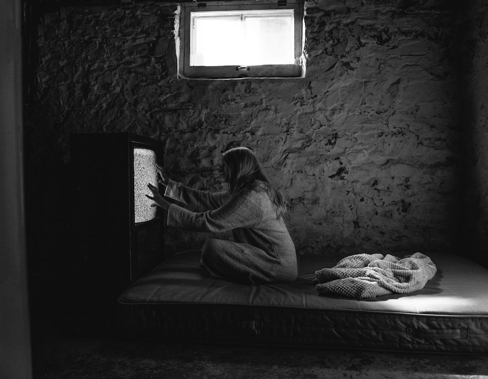 man in white shirt sitting on bed