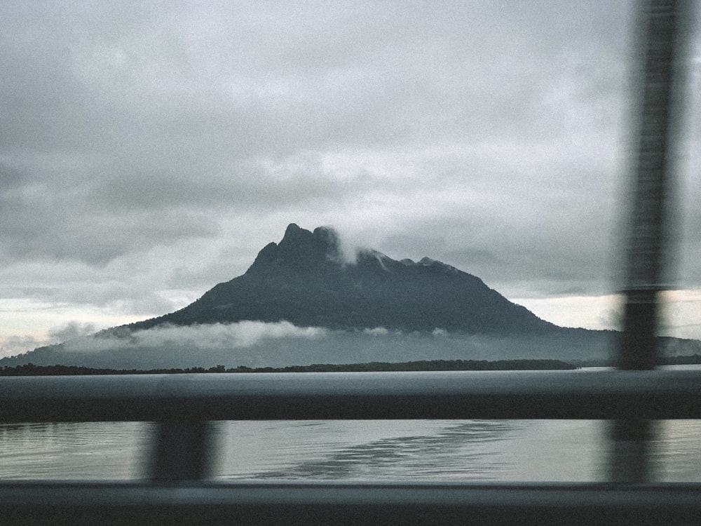grayscale photo of mountain near body of water