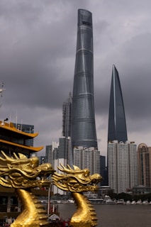 A vibrant street scene featuring a modern cityscape with mythical figures subtly integrated into the environment, such as a giant dragon perched on a skyscraper and a goddess walking among the crowd.