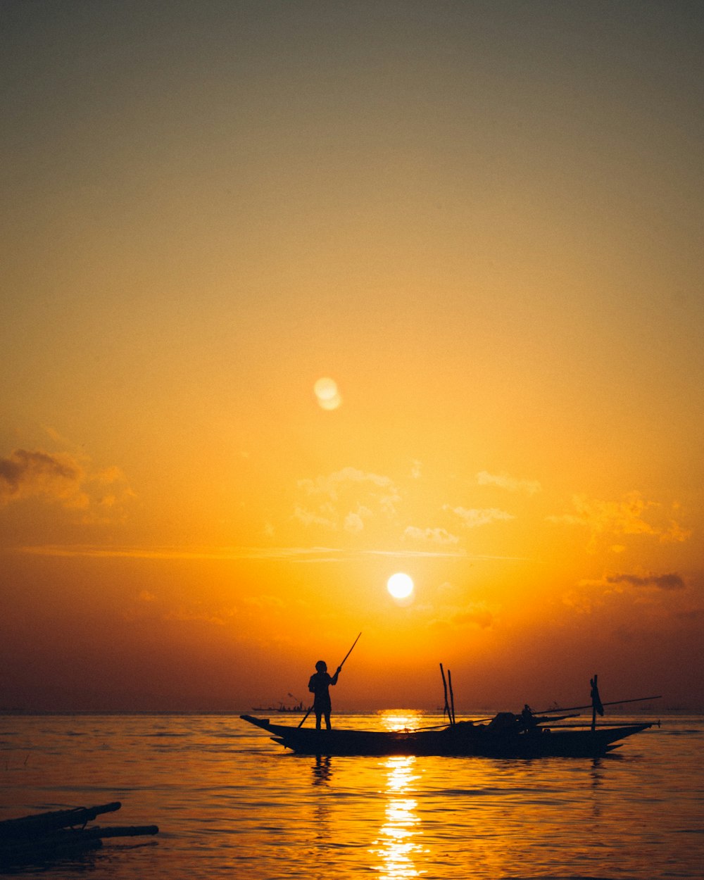 silhouette of people riding on boat during sunset