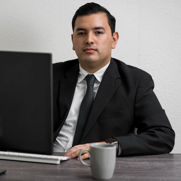 man in black suit jacket holding white ceramic mug