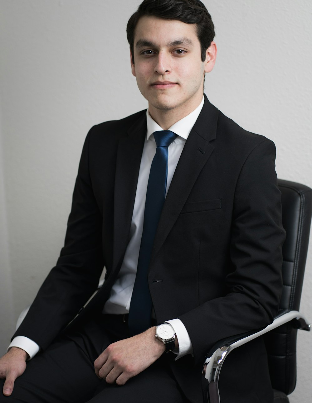 man in black suit sitting on chair