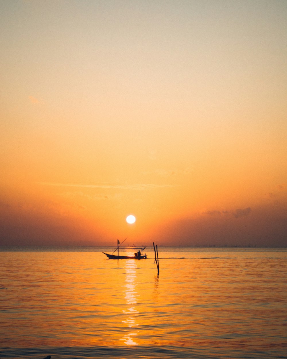 silhouette of boat on sea during sunset