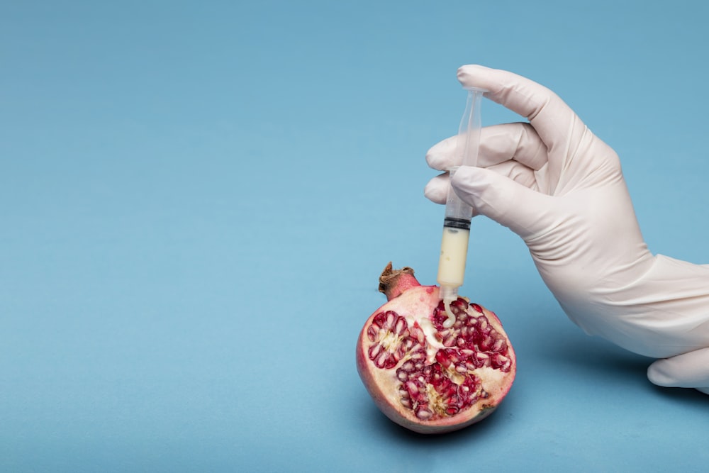 person holding sliced pomegranate fruit