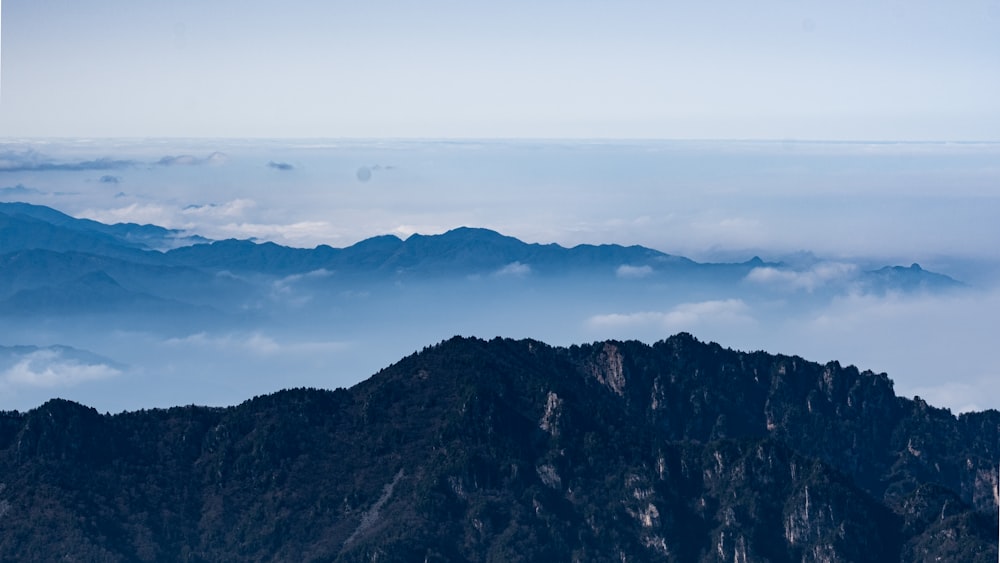 brown and green mountains under white clouds during daytime