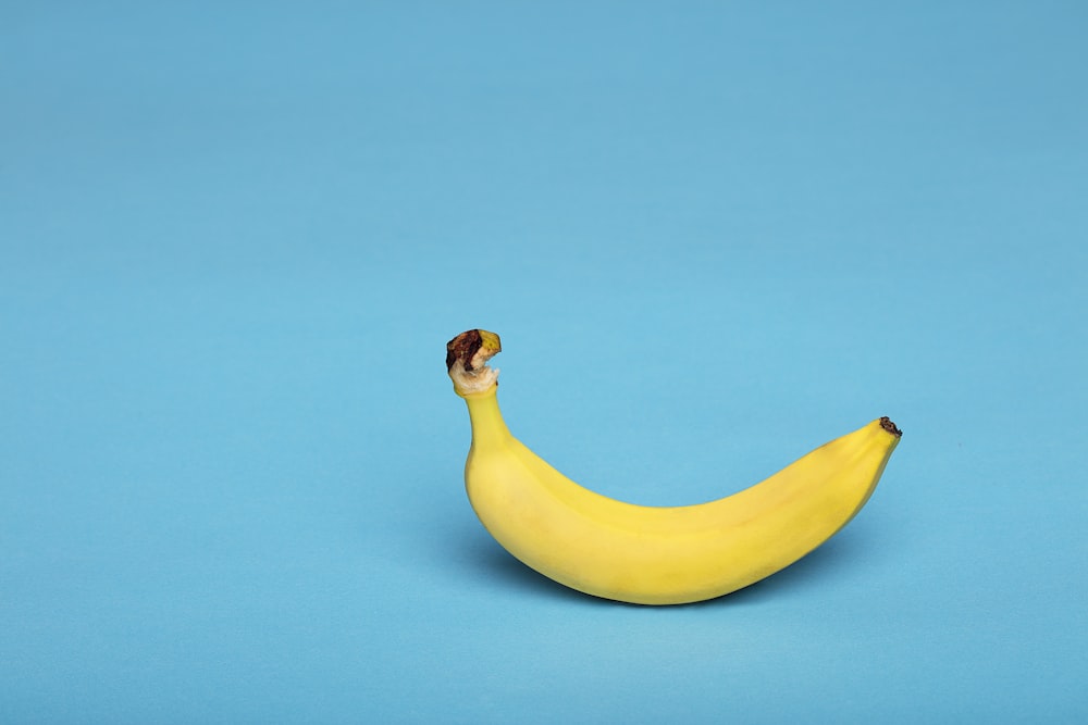 yellow banana fruit on blue surface