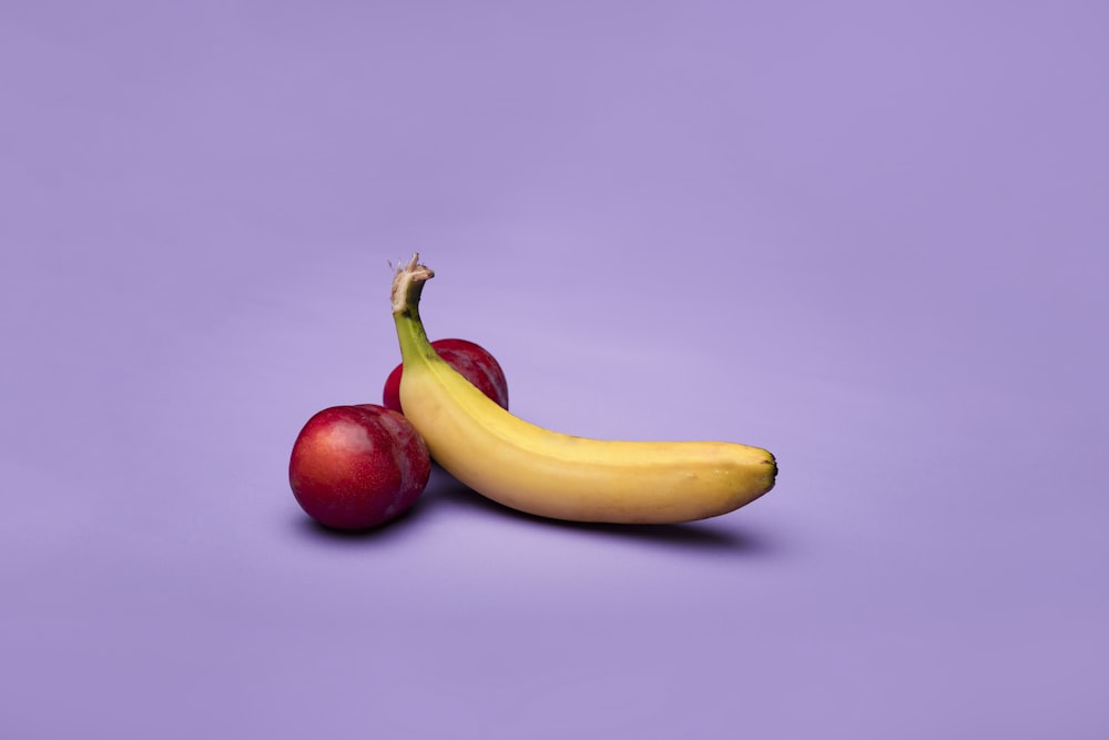 fruta de banana amarela ao lado de fruta de maçã vermelha