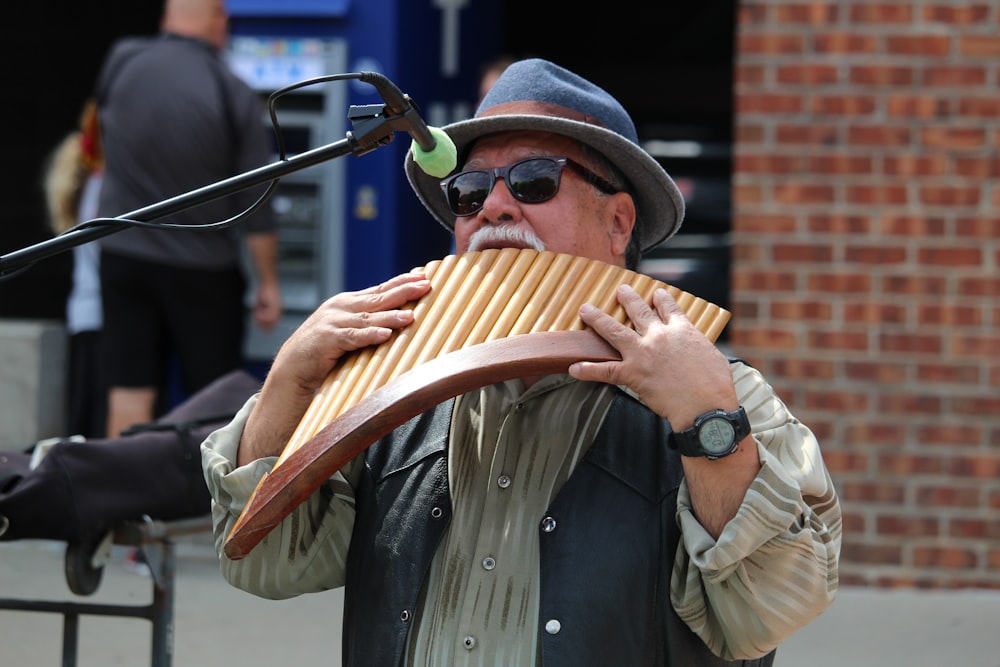 man in brown leather jacket playing brown wooden musical instrument