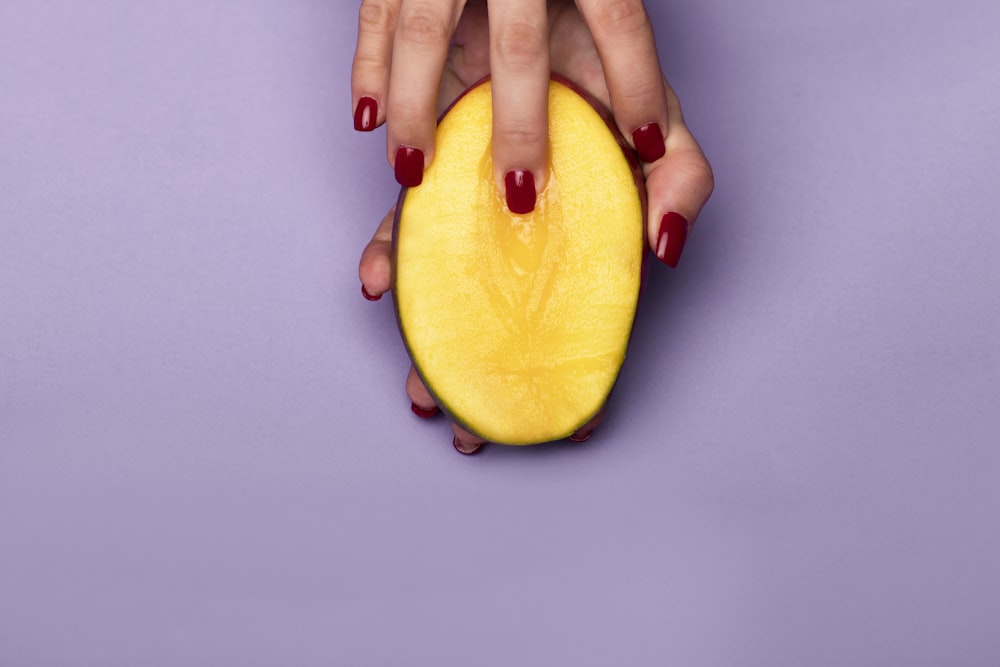 person holding sliced yellow fruit