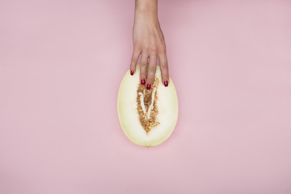 person holding sliced of green fruit