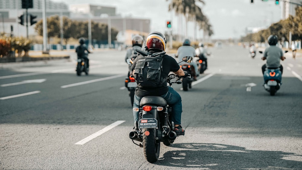 man in black motorcycle helmet riding motorcycle on road during daytime