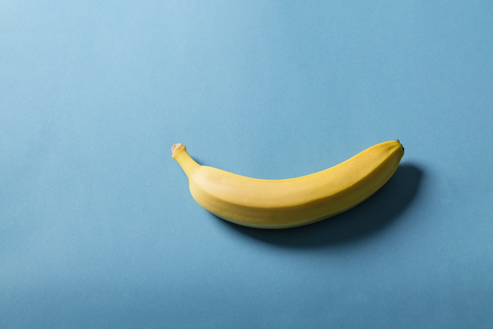 Frutto di banana gialla su superficie blu