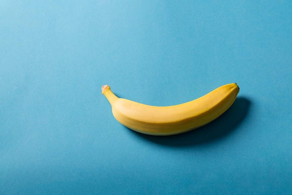 yellow banana fruit on blue surface