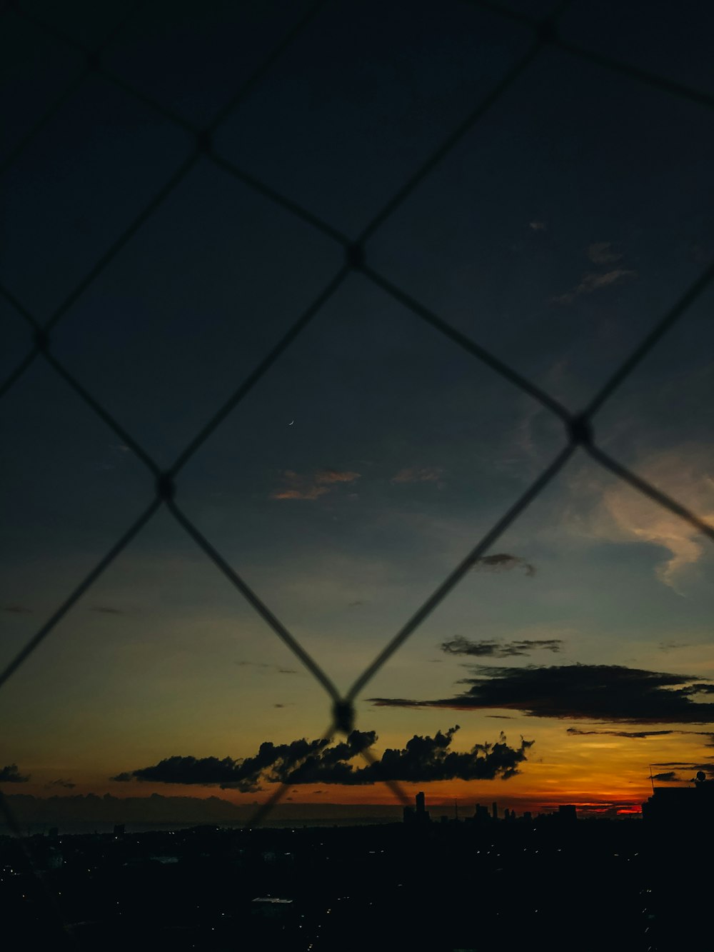 silhouette of chain link fence during sunset