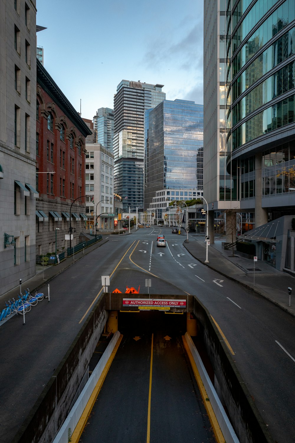 cars on road between high rise buildings during daytime