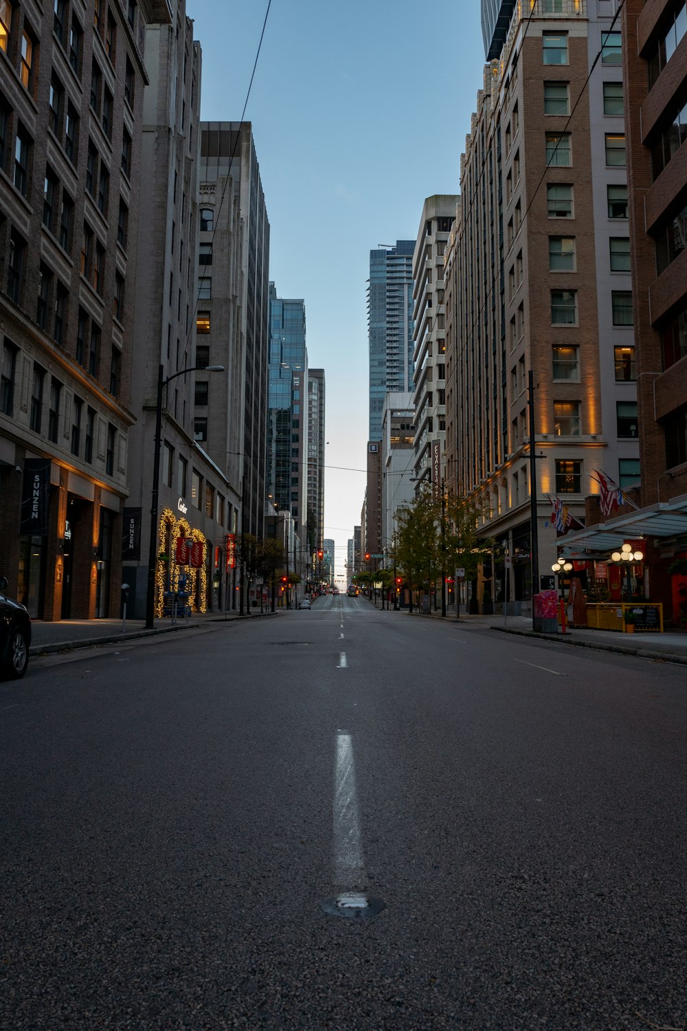 black car on road between high rise buildings during daytime