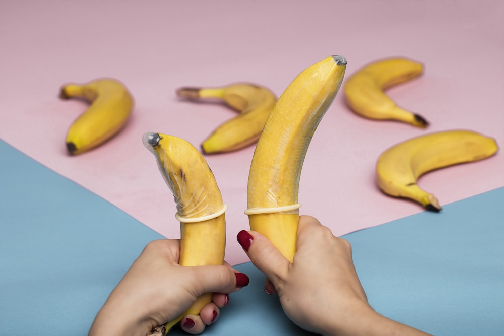 persona che tiene il frutto giallo della banana