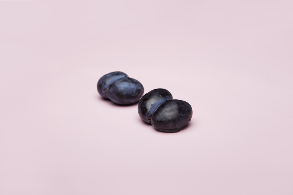 schwarze runde Früchte auf weißer Oberfläche
