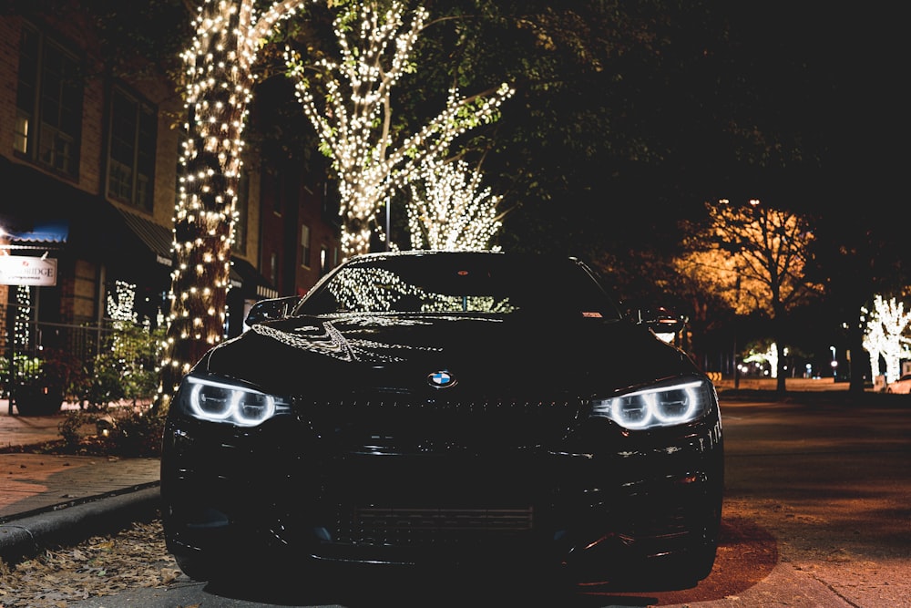 black bmw car parked near trees during night time