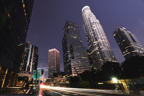 A bustling city skyline at night, lights twinkling under a clear sky, inviting adventure.