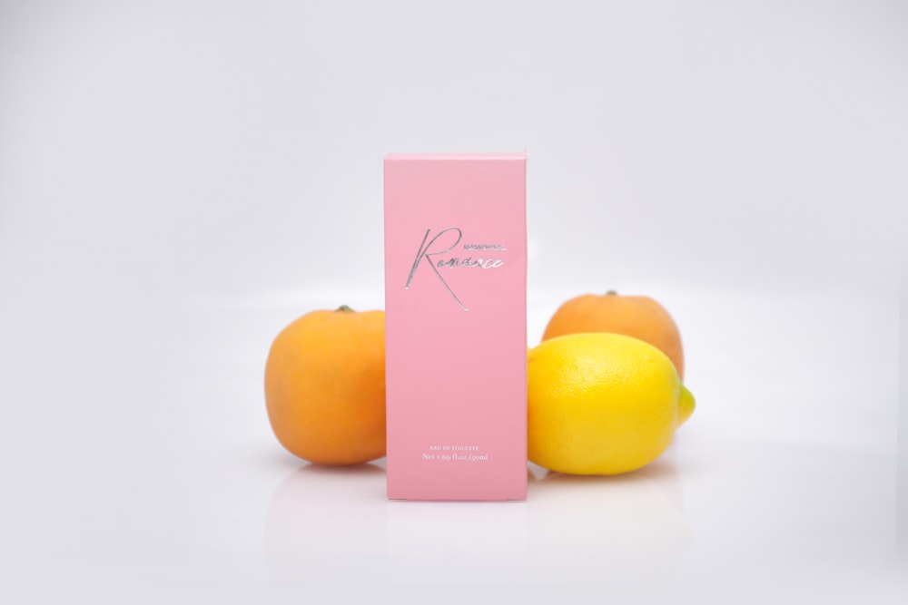 yellow citrus fruit beside pink box