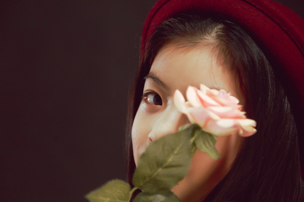 woman in red hijab holding white flower