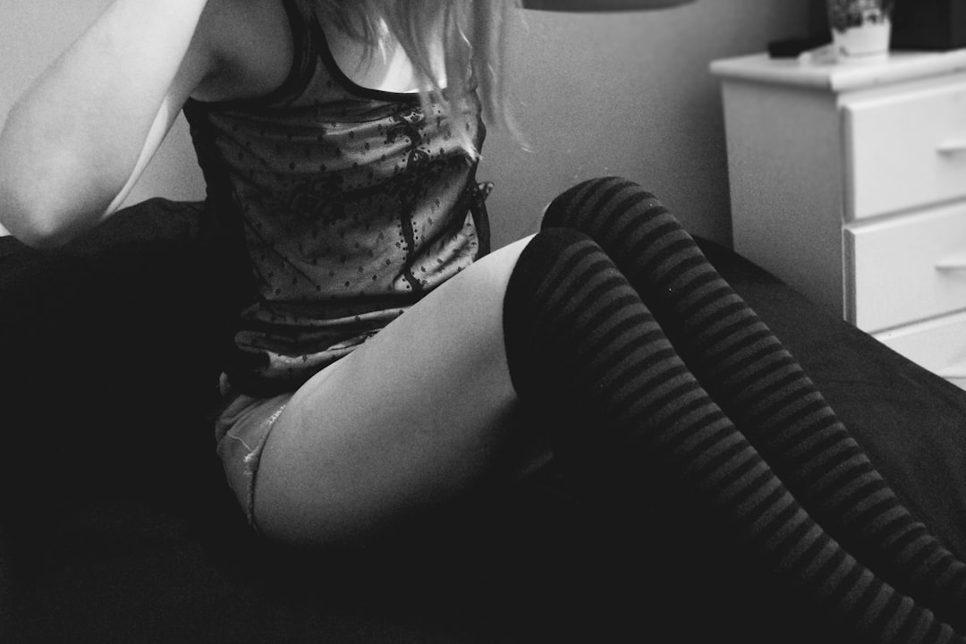 woman in tank top and black pants sitting on chair,
