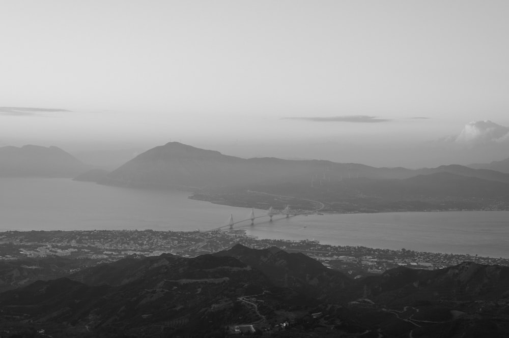 grayscale photo of bridge over the sea