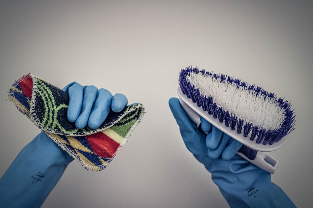 person holding green white and blue shoe