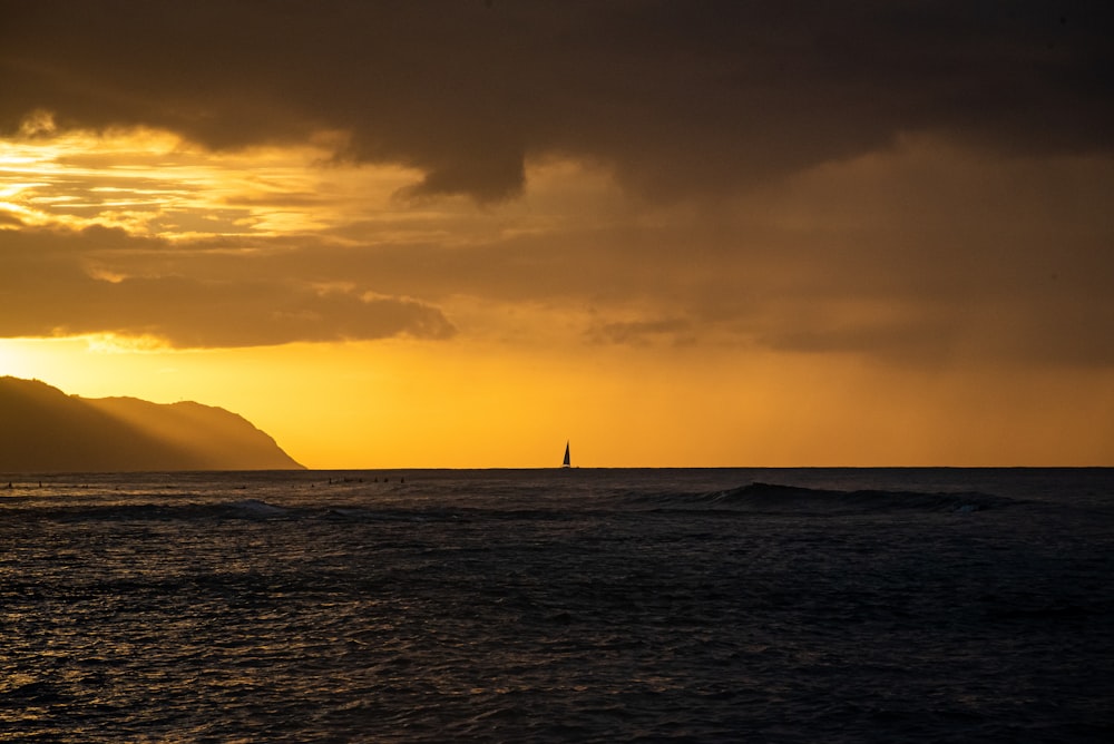Silueta de velero en el mar durante la puesta del sol