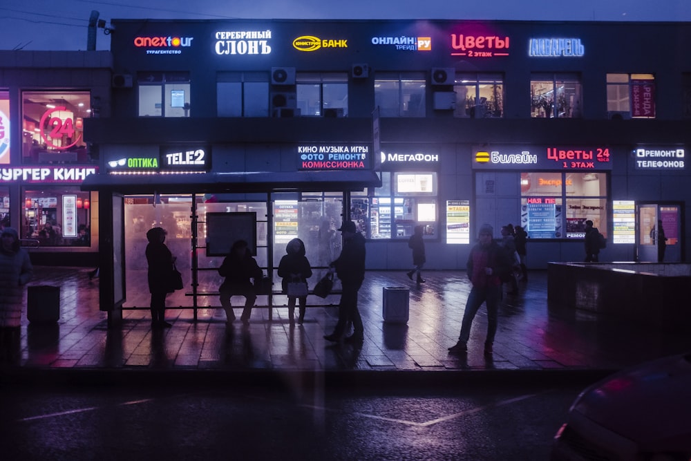 people walking on sidewalk during night time