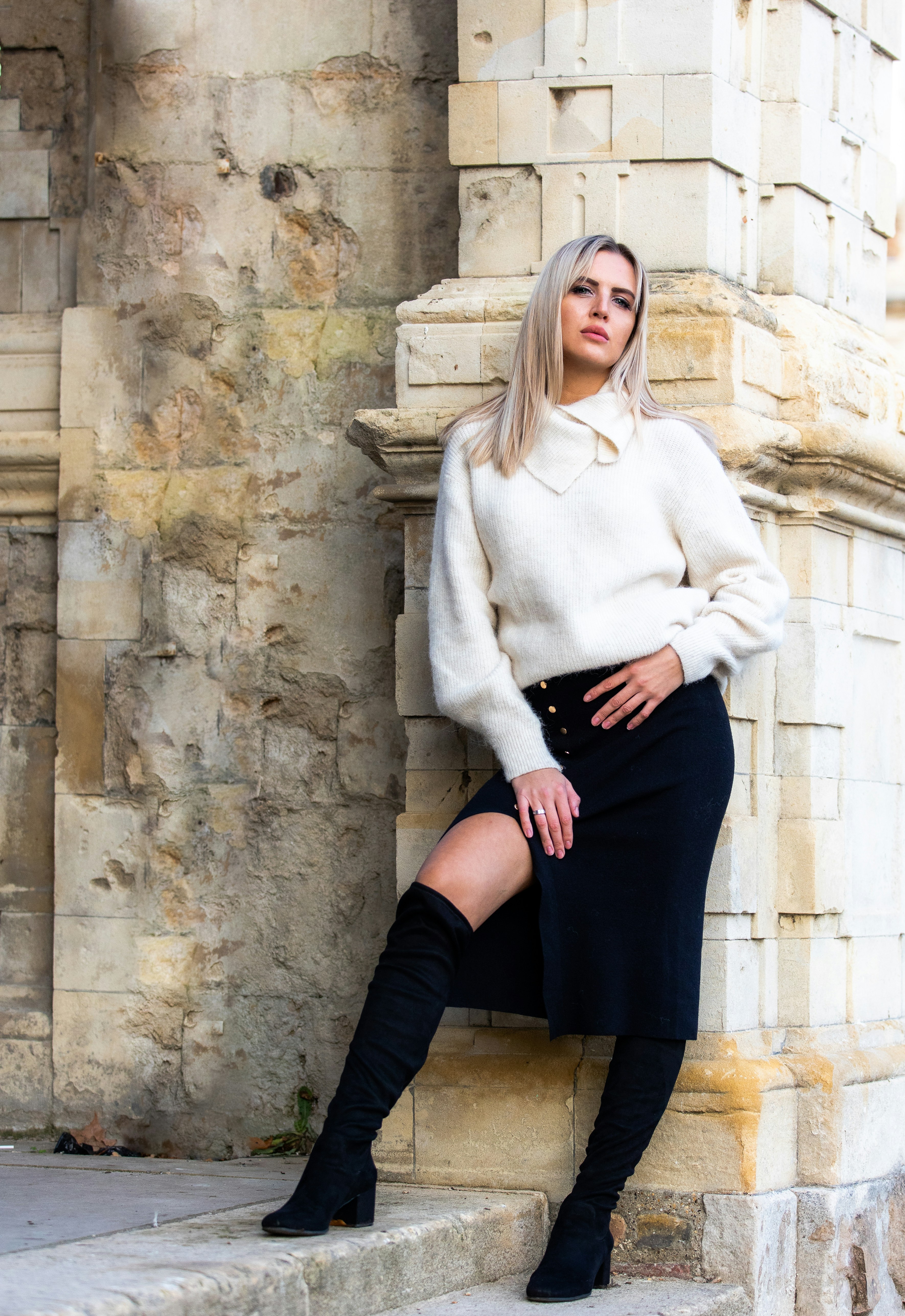 great photo recipe,how to photograph woman in white sweater and black skirt sitting on concrete wall during daytime