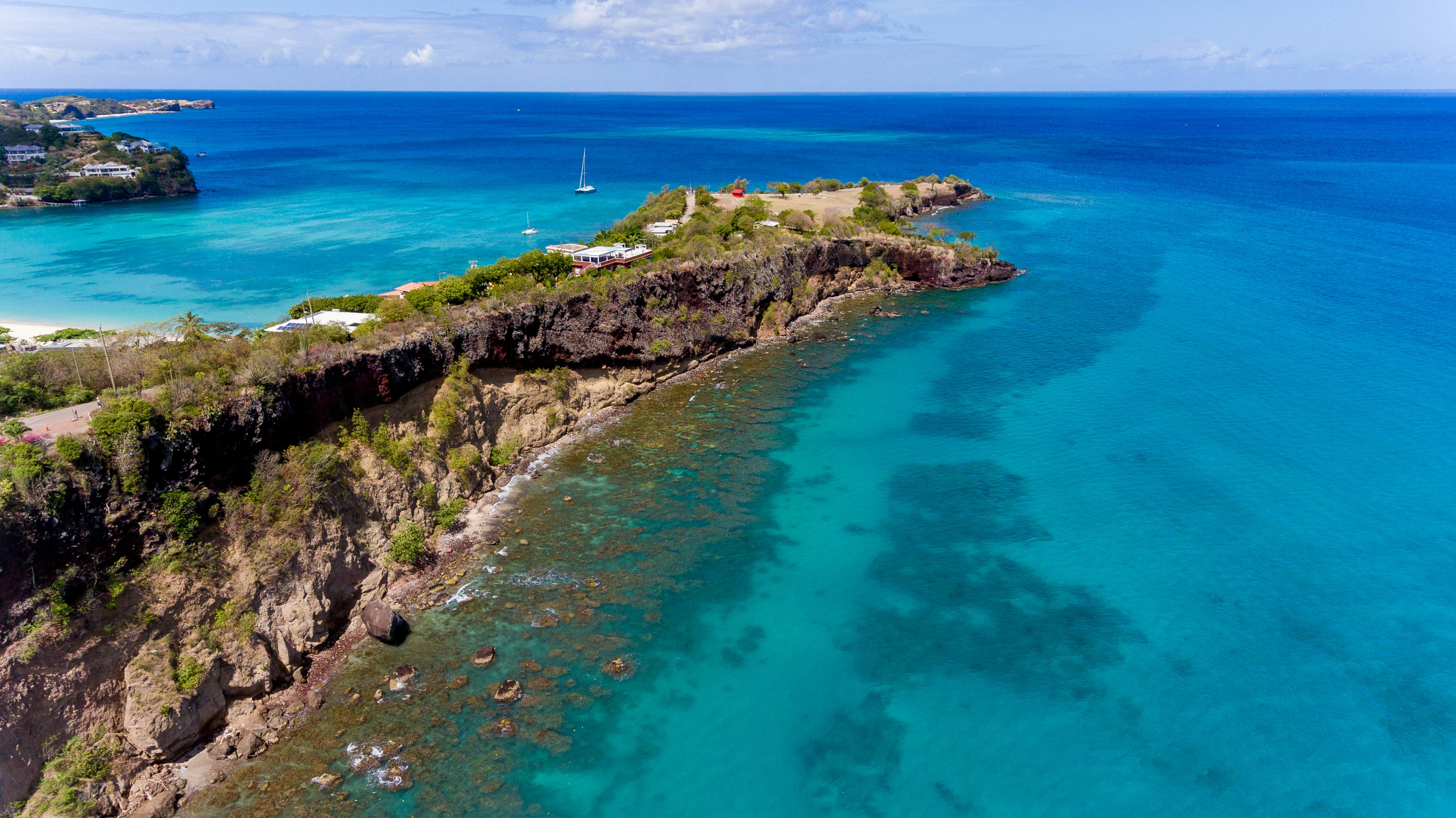 green and brown rock formation beside blue sea during daytime