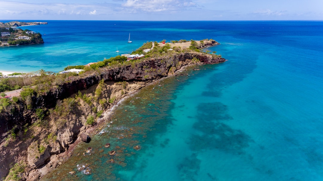 green and brown rock formation beside blue sea during daytime