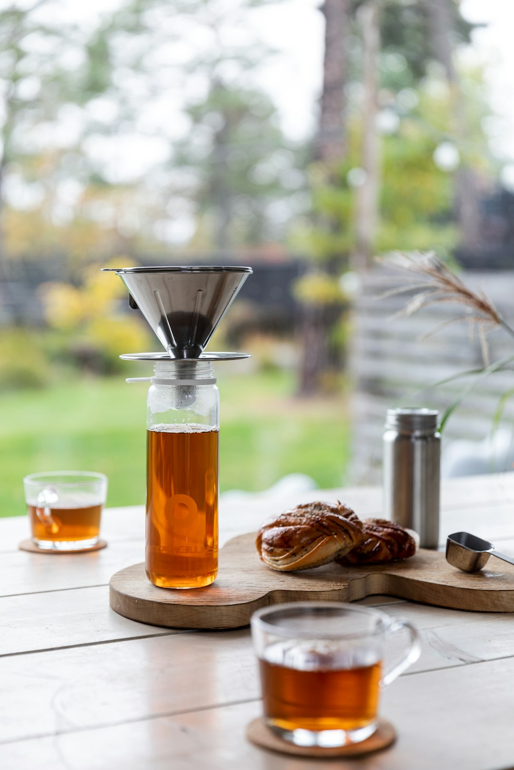 clear glass cup with yellow liquid on brown wooden chopping board