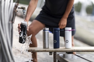 man in black t-shirt pouring water in tumbler