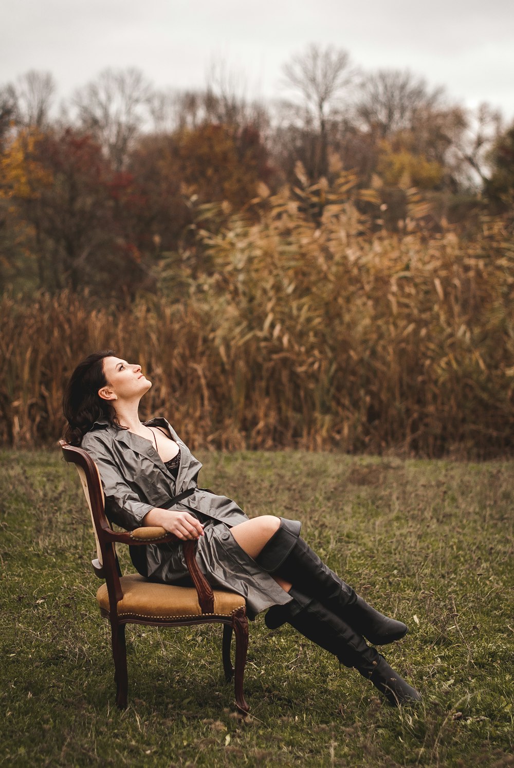 Femme en chemise noire et blanche assise sur un fauteuil en bois marron