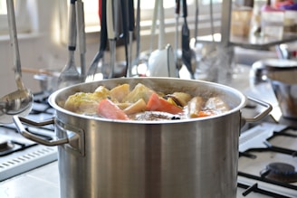 Close-up of a stainless steel stockpot filled with fresh vegetables ready for cooking.