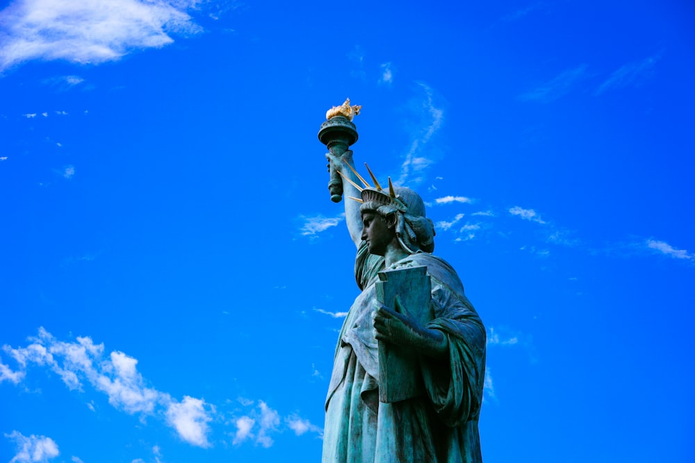 statue of liberty under blue sky during daytime