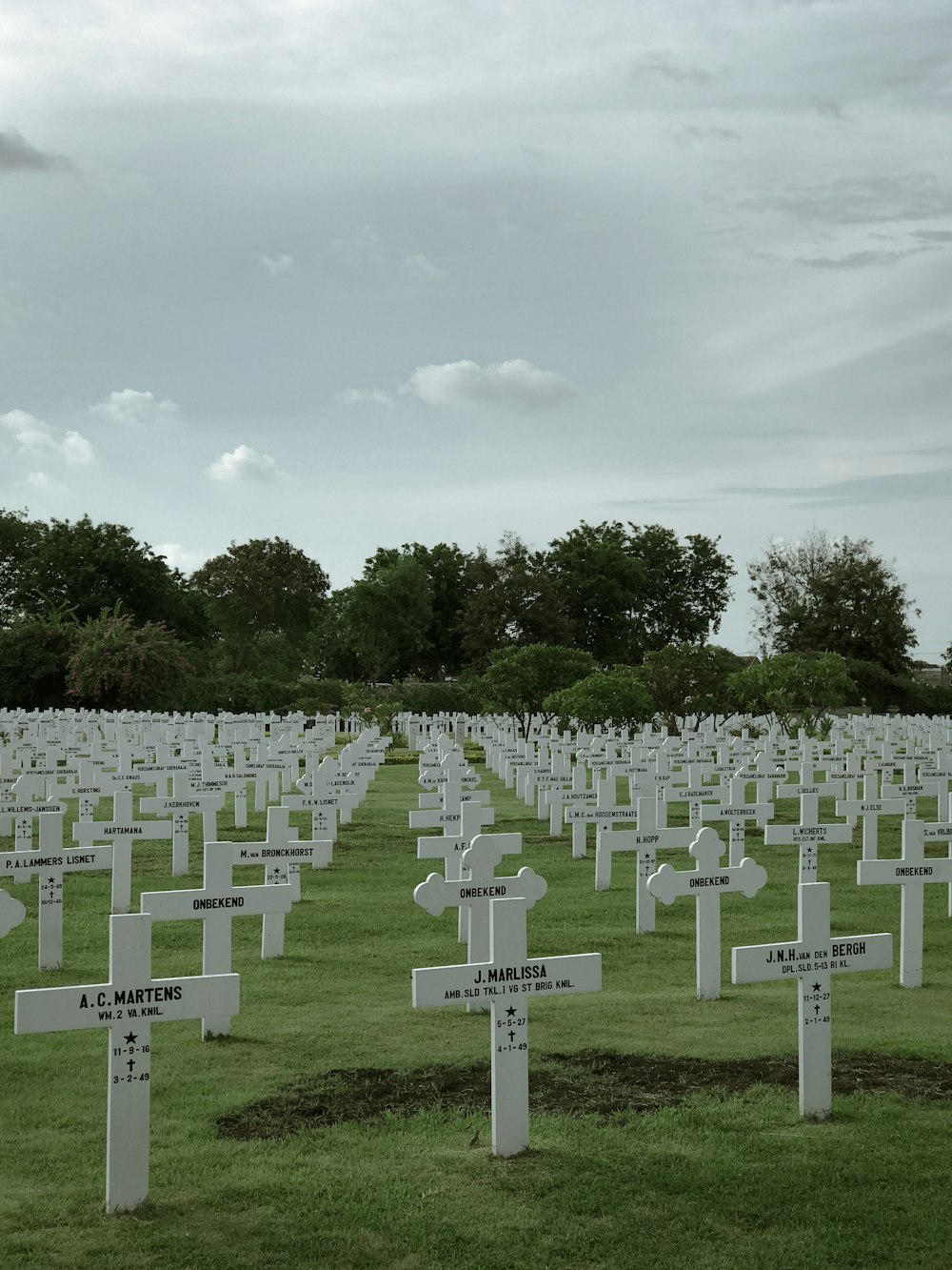 white and green cross on green grass field during daytime