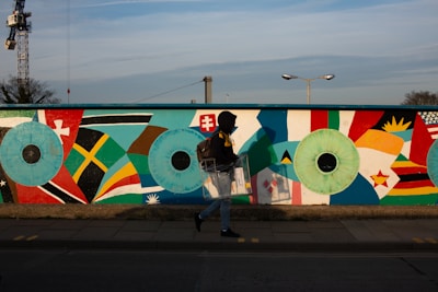 woman in black jacket and blue denim jeans holding white blue and red flag