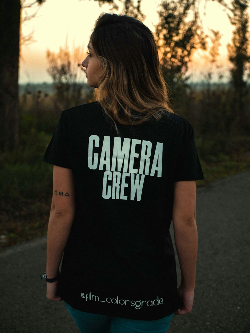 woman in black and white crew neck t-shirt standing on road during daytime