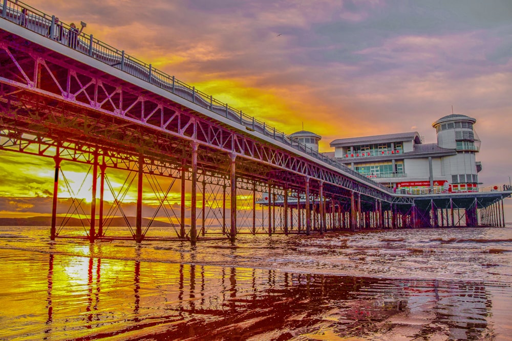 brown wooden bridge over river during sunset