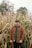 man in red and black plaid dress shirt standing in corn field during daytime