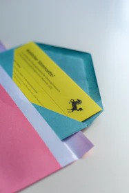 Brightly colored custom invitations and gift tags displayed alongside matching envelopes.