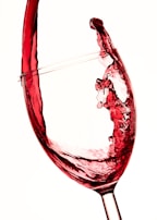 Close-up of wine swirling inside a glass, reflecting warm ambient lighting.