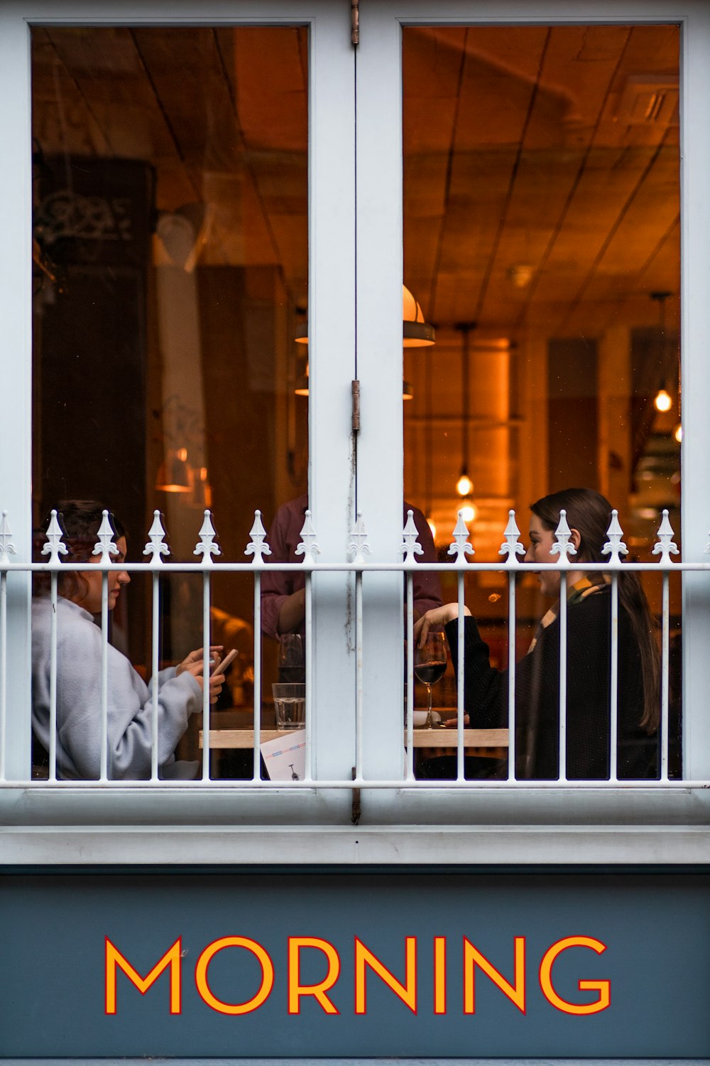 man in white dress shirt standing in front of glass window